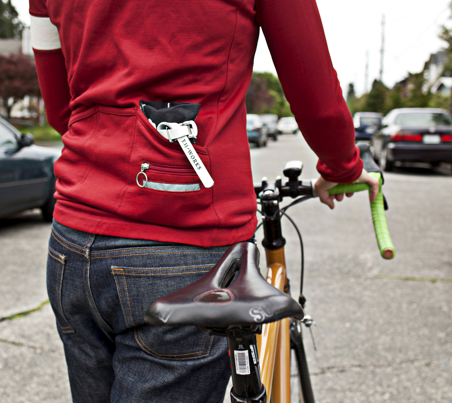 Person on a bicycle with a Sojourner tool roll tucked into their jersey's back pocket