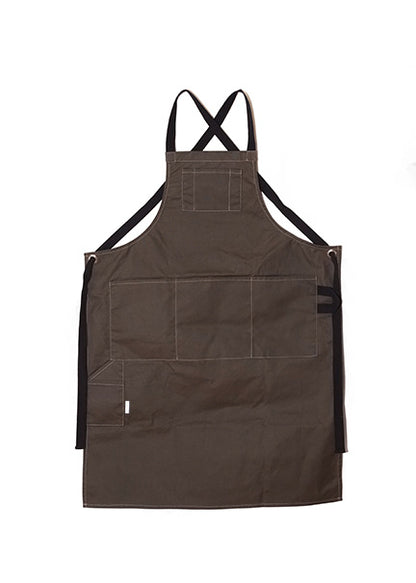 Pine canvas apron with multiple pockets and adjustable crossback straps, laid flat on a white background