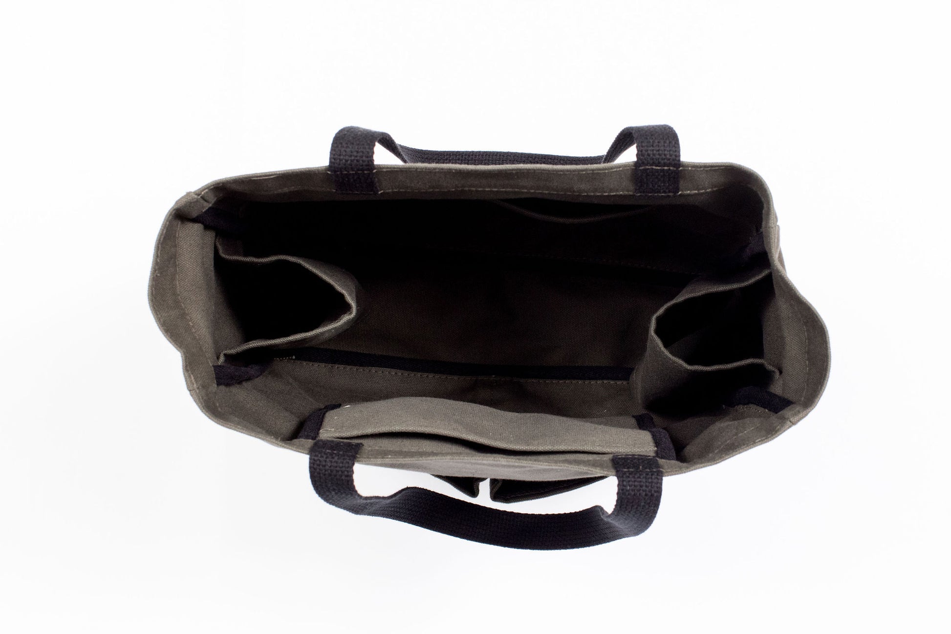 Top-down view inside an empty olive green canvas tote bag, showing interior organizer pockets and a center divider
