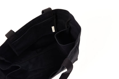 Black canvas Utility Carryall tote interior with the EH·Works brand label, multiple compartments, and webbed handles
