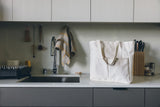 Natural canvas Utility Carryall tote on a kitchen counter with utensils and a sink in the background