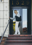 Woman carrying the Canvas Utility Carryall tote in black over her shoulder, walking up brick steps to a front door