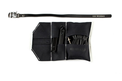  Open black canvas Sojourner tool roll with black leather trim, showing tire levers and a spare tube in the pockets