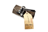 Sojourner tool roll in saddle brown canvas with black leather trim, rolled up with an EH·Works "Tool Roll" tag