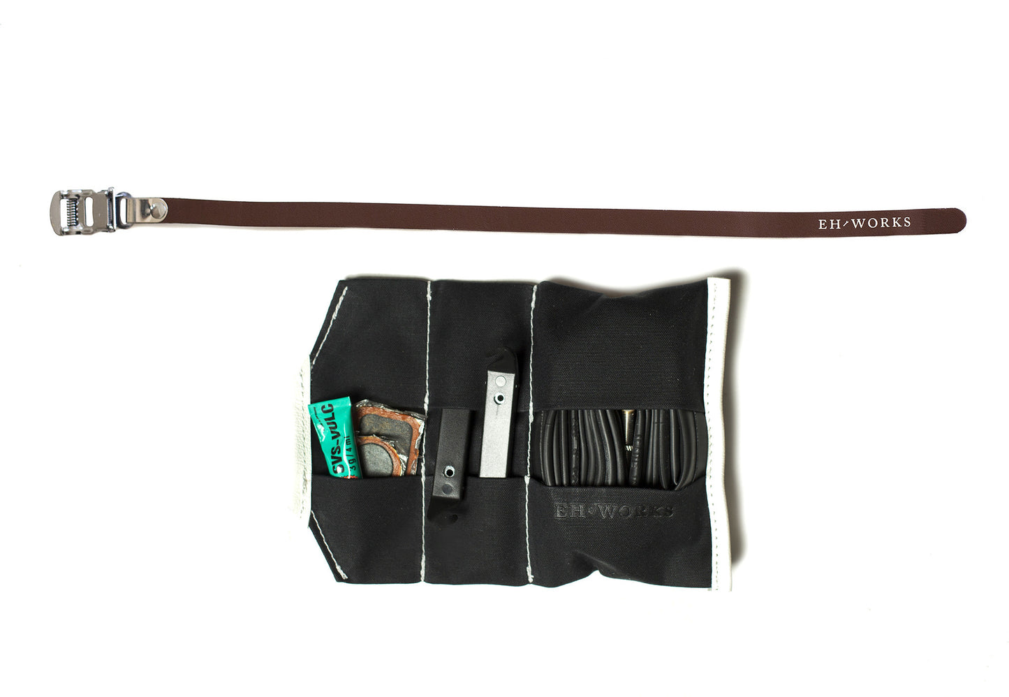  Open black canvas Sojourner tool roll with brown leather strap, showing tire levers, a patch kit, and a spare tube in the pockets